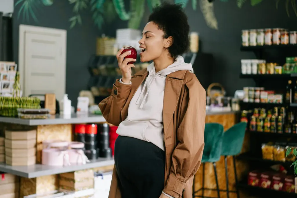 Mujer embarazada comiendo manzana