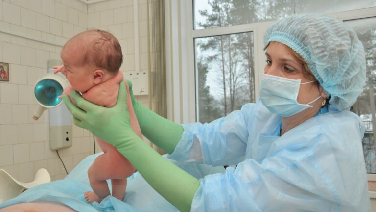 nurse holding a baby during birth