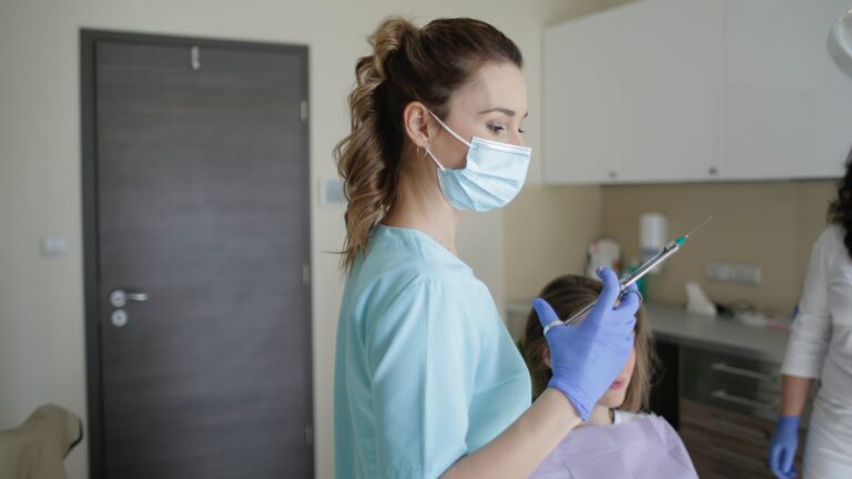 woman in teal scrub suit holding injection